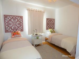 a bedroom with two beds and a chandelier at Victoria House in Atherton