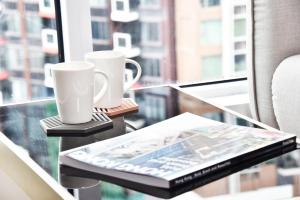 a table with two coffee cups and a newspaper on it at The Mercury in Hong Kong