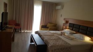 ein Hotelzimmer mit einem großen Bett und einem Stuhl in der Unterkunft Begonville Hotel in Marmaris