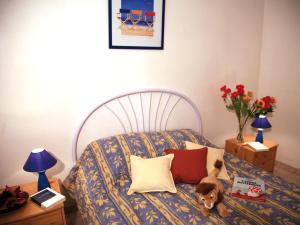 a bedroom with a bed with a dog sitting on it at Lagrange Vacances Les Trois Rivières in Mandelieu-La Napoule