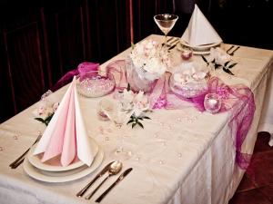einen Tisch mit einem weißen Tischtuch und rosa Servietten in der Unterkunft La Fresca in Kroměříž