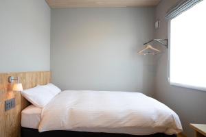 Rúm í herbergi á MASCOS HOTEL Masuda Onsen