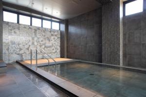una piscina con piattaforma in una stanza di MASCOS HOTEL Masuda Onsen a Masuda