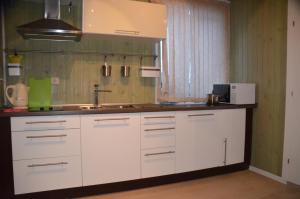 a kitchen with white cabinets and a sink at Lubimiy Prichal in Zaborki