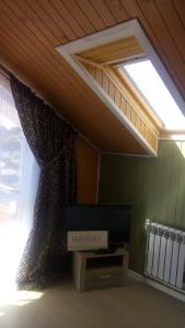 sala de estar con ventana y TV en Lubimiy Prichal, en Zaborki