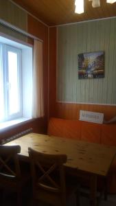 una mesa de madera y sillas en una habitación con ventana en Lubimiy Prichal, en Zaborki