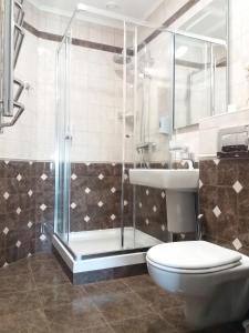 a bathroom with a shower and a toilet and a sink at Aigul Hotel in Ufa