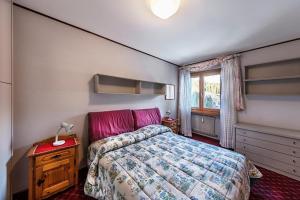 een kleine slaapkamer met een bed en een raam bij Pradalago in Madonna di Campiglio