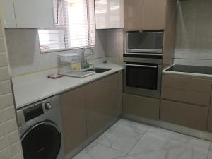 a kitchen with a dishwasher and a washer in it at AYA LUXURY APARTMENTS 99 in Durban