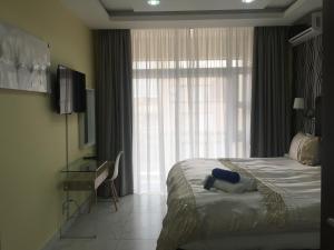 a hotel room with a bed and a window at AYA LUXURY APARTMENTS 99 in Durban