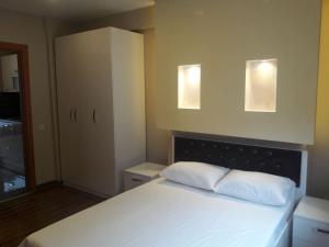 Ninve Apartments – Istanbul Bakirköy في إسطنبول: غرفة نوم بسرير ابيض مع وسادتين