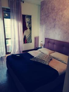 ein großes Bett in einem Schlafzimmer mit Porträt einer Frau in der Unterkunft Residence Vigliani in Mailand