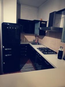 Il comprend une cuisine équipée d'un réfrigérateur noir et d'une cuisinière. dans l'établissement Residence Vigliani, à Milan