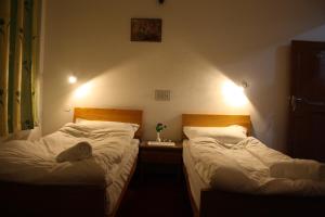 two beds in a small room with at Hotel Khan Manzil in Leh