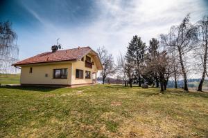 a small house on a grassy field with trees at Luxury Apartment Ana with Hot tub in Višnja Gora