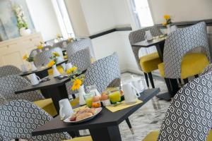 a restaurant with tables and chairs with food on them at Hotel Carlton in Beaulieu-sur-Mer