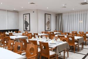 a dining room with white tables and wooden chairs at Villa Verica in Baška Voda