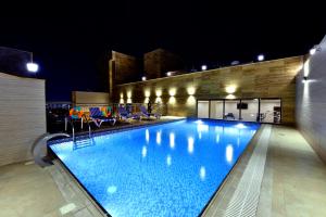 a large swimming pool at night with lights on it at Iridium 70 Hotel in Jeddah