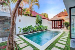 una piscina en el patio trasero de una casa en Clover Villa Sanur, en Sanur