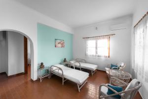 um quarto de hospital com três camas e uma janela em Cavo Grosso Bungalows em Mavrovoúnion