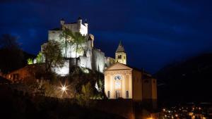 a castle sitting on top of a hill at night at Studio CENTRAL 2 in Aosta