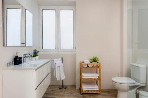 a white bathroom with a sink and a toilet at Genteel Home Zegrí in Málaga +14 photos