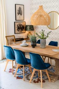 een eetkamer met een houten tafel en blauwe stoelen bij Genteel Home Zegrí in Málaga