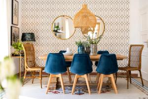 a dining room with a wooden table and blue chairs at Genteel Home Zegrí in Málaga
