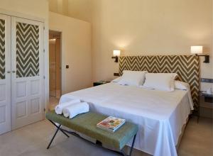 a bedroom with a large white bed and a table at Trafalgar Polo Club in El Palmar