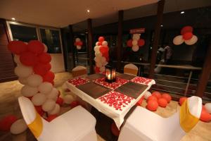 um quarto com uma mesa com um monte de balões em Hotel Eefa em Belgaum