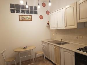 a kitchen with white cabinets and a sink and a table at B&B Casa Alessandro in Scalea