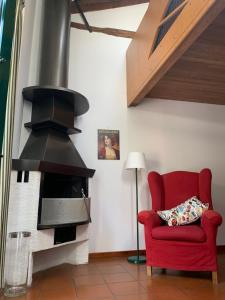 un soggiorno con una sedia rossa e un camino di Le Residenze dei Serravallo a Trieste
