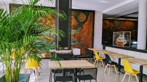 un ristorante con tavoli e sedie in legno e un murale di Hotel Mira-Mar a Valras-Plage Altre 55 foto