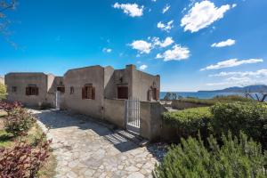 a house with a fence in front of it at Cavo Grosso Bungalows in Mavrovouni