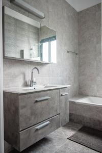 a bathroom with a sink and a tub and a mirror at Julipapas Gardens in Paphos