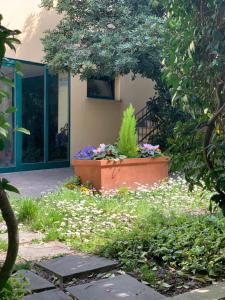 a garden with flowers in front of a building at Le Residenze dei Serravallo in Trieste