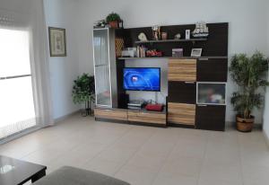 uma sala de estar com televisão numa prateleira em Meddays Chalet Chimeno em Miami Platja