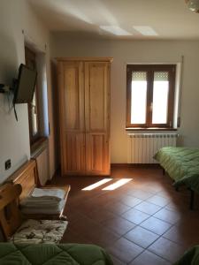 um quarto com duas camas e uma televisão e janelas em Agriturismo Fiorella em Camigliatello Silano