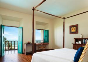 a bedroom with a bed and a balcony at Jetwing Lighthouse in Galle