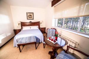 um quarto com uma cama, uma mesa e uma janela em Alda Cabanas Playa em Cabanas