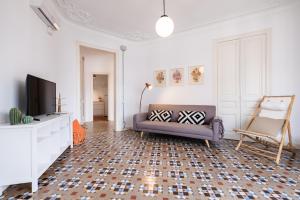 ein Wohnzimmer mit einem Sofa und einem TV in der Unterkunft b32-Sunny and Modernist apartment for groups in center in Barcelona