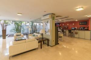 a living room with couches and a table and a kitchen at Hotel Colon Rambla in Santa Cruz de Tenerife