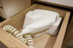 a white electric hair dryer in a wooden box at Ra Premiere Simatupang Jakarta in Jakarta