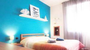 een slaapkamer met een blauwe muur met een bed en een tafel bij Casa San Raffaele in Vimodrone