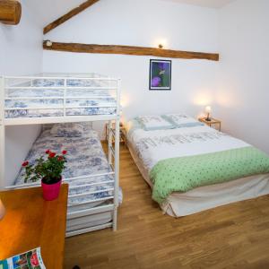 1 Schlafzimmer mit 2 Etagenbetten und einem Tisch in der Unterkunft Chambres d'hôtes Entre Dolmens et Fontaines in Buzeins