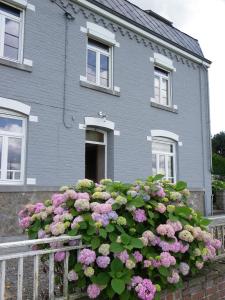 une maison avec un bouquet de fleurs devant elle dans l'établissement B&B Au Bord De La Source, à Soy