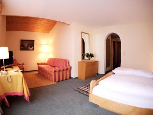 a hotel room with a bed and a chair at Pension Grissemann in Lech am Arlberg +41 photos