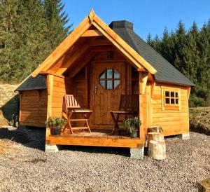 
a wooden cabin with a wooden table and wooden cabinetry at The Nest Glamping Pod in Dalmally
