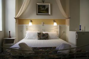 una camera da letto con un grande letto con una grande testiera di Fiera Guesthouse a Ermoupoli
