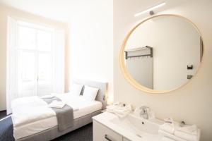 1 dormitorio con cama, espejo y lavamanos en Narodni Stay, en Praga